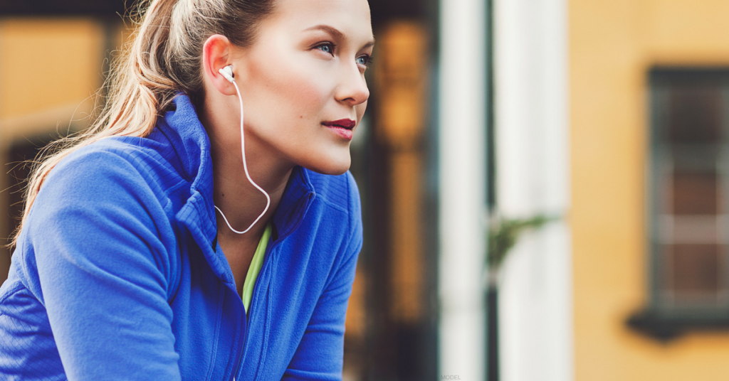 Young woman wearing ear buds looking ahead