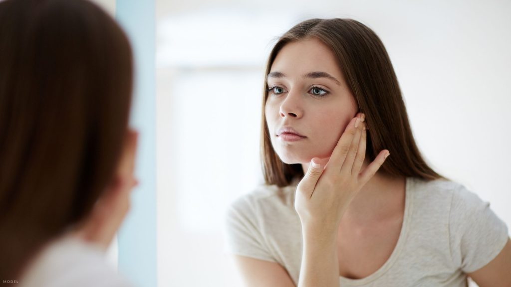 Woman looking in mirror after Botox® in Atlanta, GA.