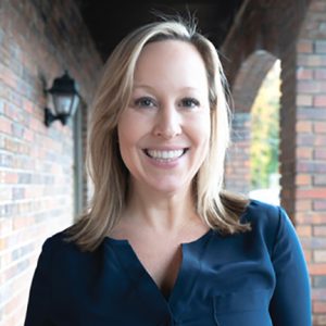 Dr. Scaljon of Buckhead Facial Plastic Surgery in blue top in brick hallway
