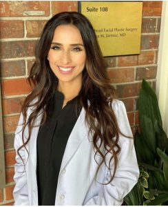 Rabia Khan NP in lab coat in front of brick wall